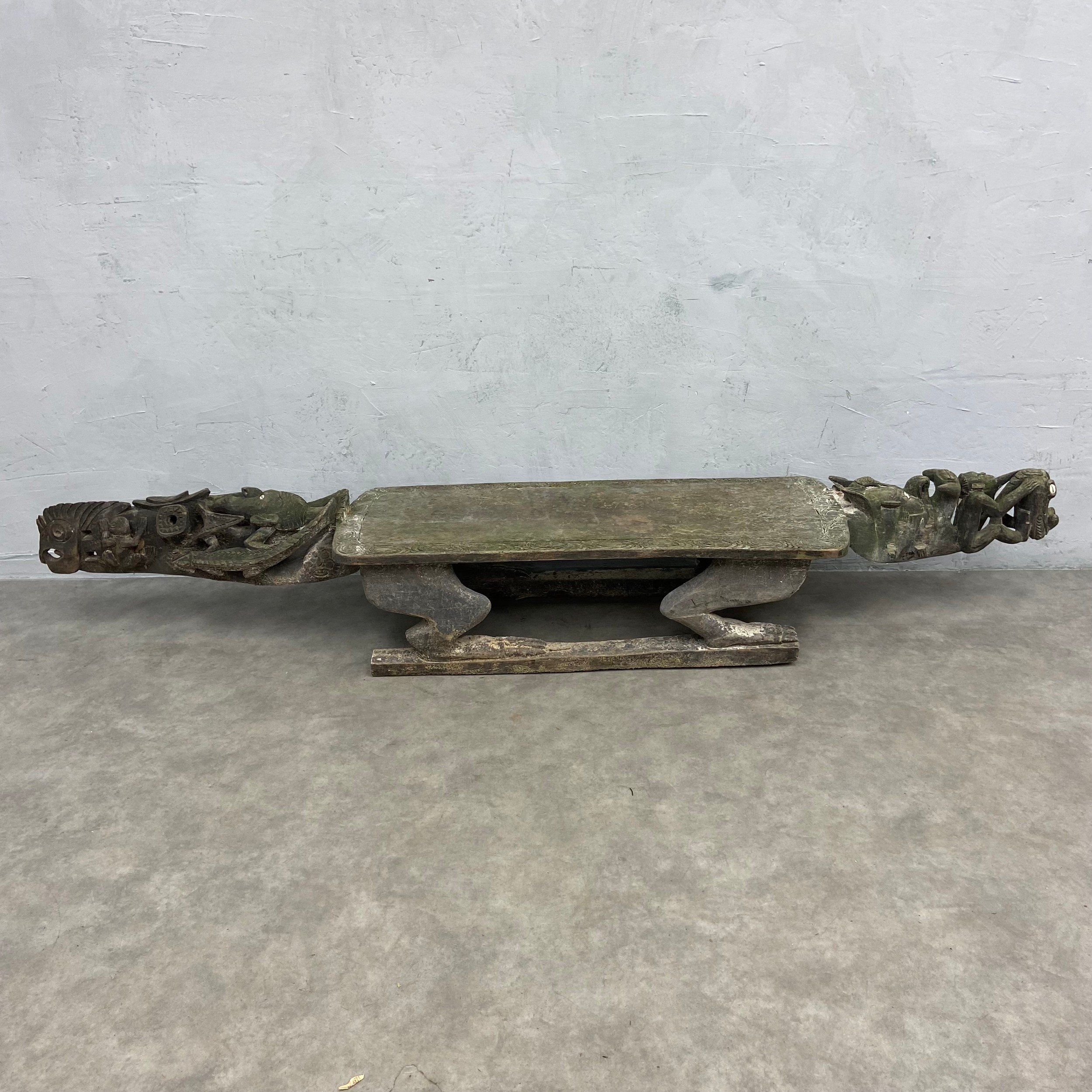 A 20th century African tribal hardwood ceremonial bench of abstract figural form with carved