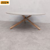 A contemporary Edda coffee table with a circular concrete top raised on splayed interlocking oak