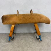A mid-century tan suede upholstered gymnastic pommel horse raised on extendable splayed square