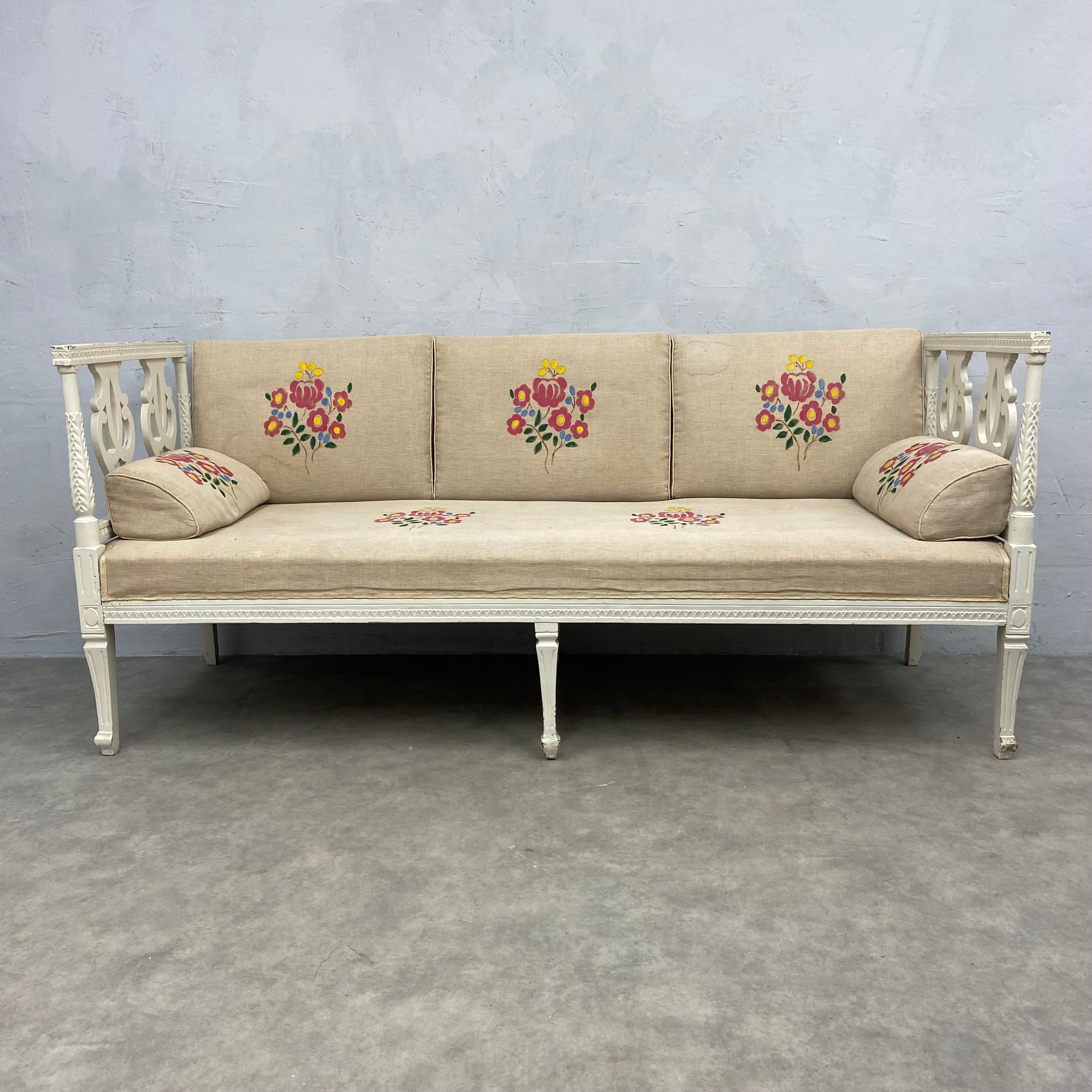 A 19th century Gustavian window seat or day bed with needlework upholstered seat raised on a painted