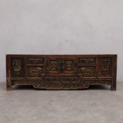 A C.1900 Chinese hardwood cabinet with an arrangement of carved drawers and doors. H.47 W.140 D.43.