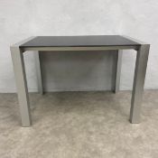 A vintage dining or centre table with black composite top raised on straight faceted brushed metal