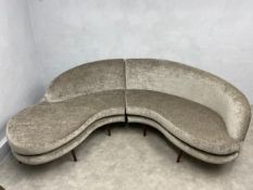 A contemporary velour upholstered modular sofa in two parts of asymmetrical curvilinear form