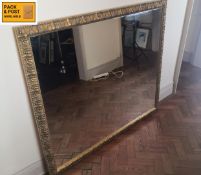 A large contemporary overmantel mirror in scrolling foliate gilt frame. 135x115cm. (Fitted with