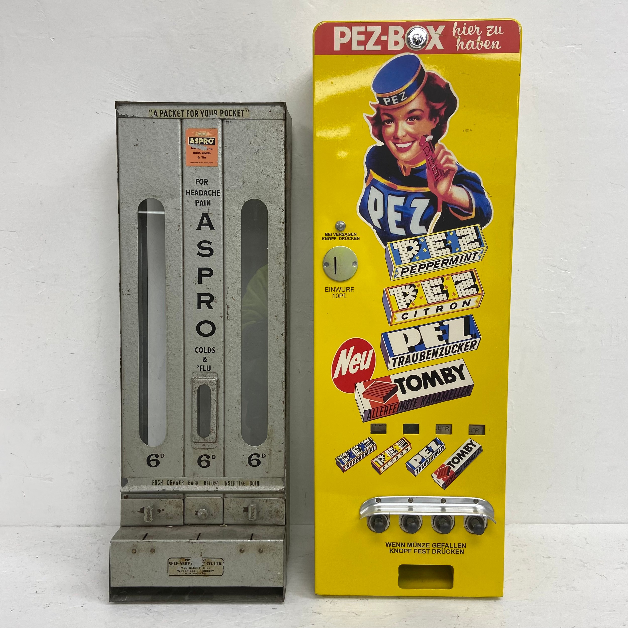 A mid-century metal cased Aspro vending machine together with a later German Pez dispenser. H.77 W.