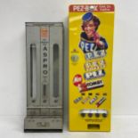 A mid-century metal cased Aspro vending machine together with a later German Pez dispenser. H.77 W.