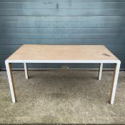 A contemporary bent oak plywood dining table raised on straight square section supports by Unto This