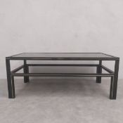 A vintage black painted metal coffee table with a square black glass inset top raised on straight