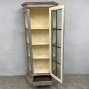 A 19th century painted and distressed display cabinet or vitrine of faceted form with moulded