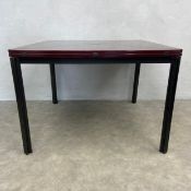 A 1970s T92 extendable dining table having a burgundy lacquered envelope top with revolving action