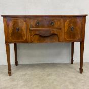 An Georgian style mahogany serpentine fronted sideboard with two figured frieze drawers flanked by a