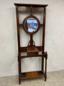 An early 20th century oak hallstand with central circular mirror over the lidded glove box flanked