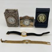 An Edwardian miniature silver hallmarked carriage clock with swing handle over the repousse case and