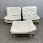 A pair of mid 20th century white leather lounge chairs on shaped steel trestle supports together