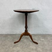 A Georgian mahogany wine or lamp occasional table with circular figured top over the turned stem