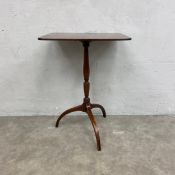 A Georgian mahogany wine or lamp occasional table with square top over a turned baluster form stem