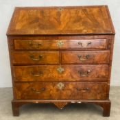 An early Georgian burr walnut, crossbanded and satinwood strung bureau with fall front revealing a
