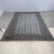 A Bokhara carpet with repeated gul motifs on a powder blue ground within multiple stylised