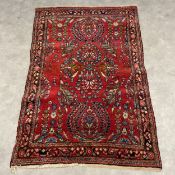 A Persian Sarouk rug with central foliate pole medallion in a polychrome field over an iron red