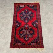 A Persian Taleghan rug with central diamond lozenge medallions with stepped spandrels over a box red