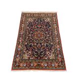 A Persian Kashan rug with central flowerhead medallion and scrolling polychrome field over the