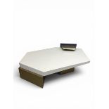 A contemporary coffee table having a white lacquered irregular pentagonal top raised on two offset