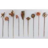 Seven Victorian and later yellow metal stick pins, mostly set with garnets, 18.4 grams, largest