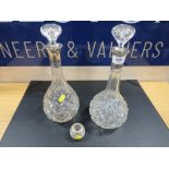 A pair of hallmarked silver collared decanters together with a silver rimmed match strike / holder