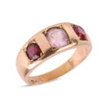 A gem-set dress ring, gypsy-set with an oval-cut red spinel, a pale pink spinel, and a garnet, to