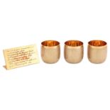 Gerald Benney - three 18ct gold goblets and dedication stand; the goblets forged with bark-effect