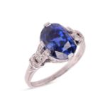An unheated Ceylon sapphire and diamond dress ring, featuring a central oval mixed-cut sapphire of