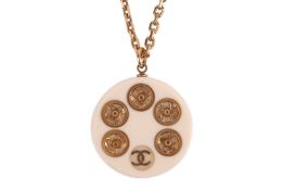 Chanel - Autumn 2003, a circular pendant in cream and clear acrylic, inset with gilt metal poppers a