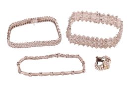 A group of three diamond-set bracelets and a single earring; the largest bracelet consisting of flex