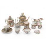 A CANTONESE EXPORT TEAPOT of cylindrical form, another smaller, two covered jars, a sauce boat, a