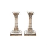 A MATCHED PAIR OF SILVER CORINTHIAN CANDLESTICKS