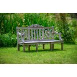 A CARVED TEAK 'HAREWOOD' GARDEN BENCH, IN THE MANNER OF THOMAS CHIPPENDALE, CONTEMPORARY