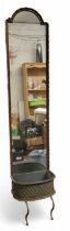 An early 20th century cast iron conservatory mirror, arched back, integrated basket to base,