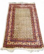 A Persian Sarouk woollen rug, boteh pattern in cream and red, 160cm x 89cm