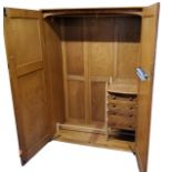An Ercol  Windsor model 431 elm wardrobe, slight convex top, panelled doors, the interior fitted