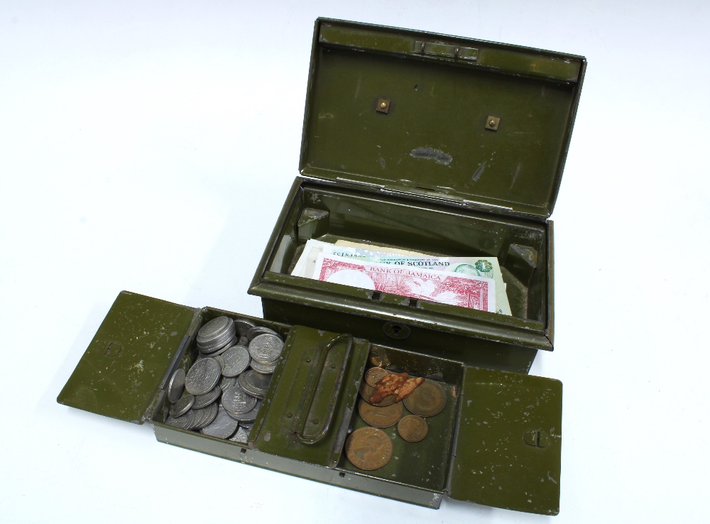 Green cash tin containing shillings and some other vintage banknotes ...