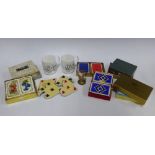 Box containing playing card related items, including two mugs, a small globe, suite coasters, and