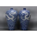 A pair of Yuan Dynasty blue-and-white porcelain plum vases with carved sea dragon and wave patterns