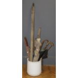 A selection of umbrellas, riding crops and walking sticks plus three vintage cane fishing rods