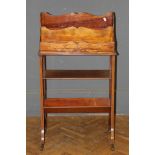 An Edwardian mahogany, ribbon swag inlaid and strung canterbury book trough, raised on splayed