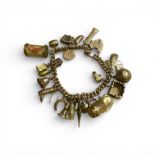 A 9ct gold charm bracelet, with 25 charms and a heart padlock clasp. Some charms in as found
