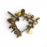 A precious yellow metal charm bracelet with 23 charms and a heart padlock clasp. 11 of the charms