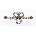 A Victorian sapphire, diamond and garnet set bow brooch, the central bow set to the centre an oval