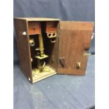 An early 20th Century antique brass microscope with accessories.