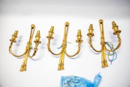 Three matching gilt metal wall lights in the Regency style, 32cm long.