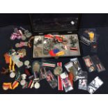 A collection of  post WWII German, French, Italian medals, tunic badges, ribbons and cap badges,